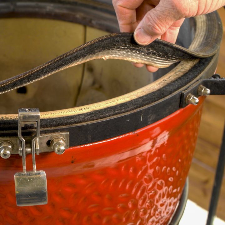 Removing the old gasket from a Kamado Joe.